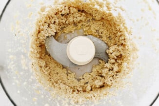 A food processor is being used to grind up cashews.