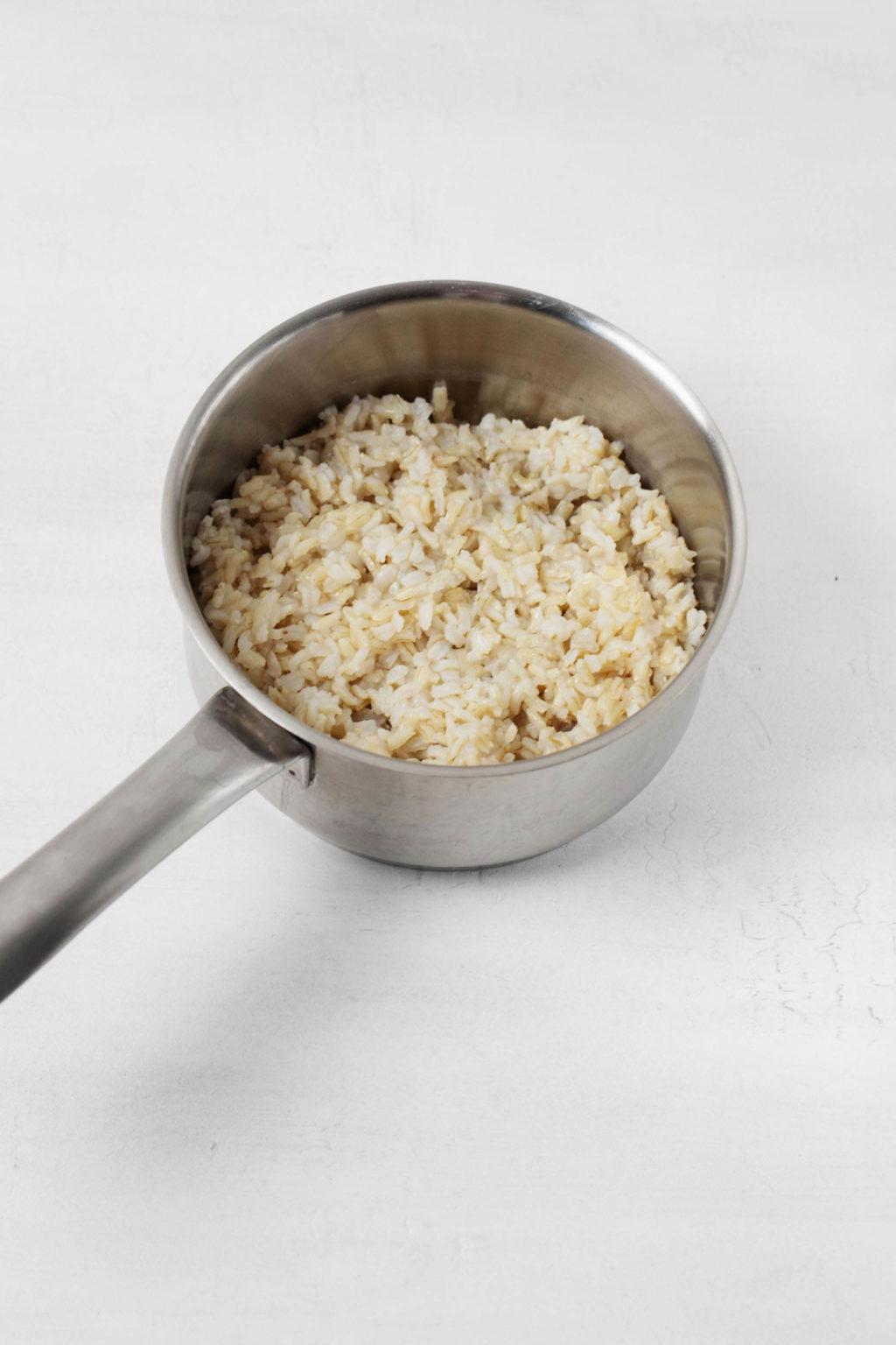 A small sauce pot is filled with brown rice.