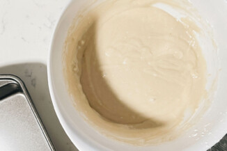 Cake batter has been prepared in a large, white mixing bowl.