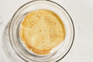A glass bowl contains vegetable oil and other liquid ingredients.