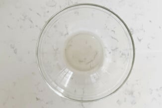 A pyrex mixing bowl is filled with a clear liquid.