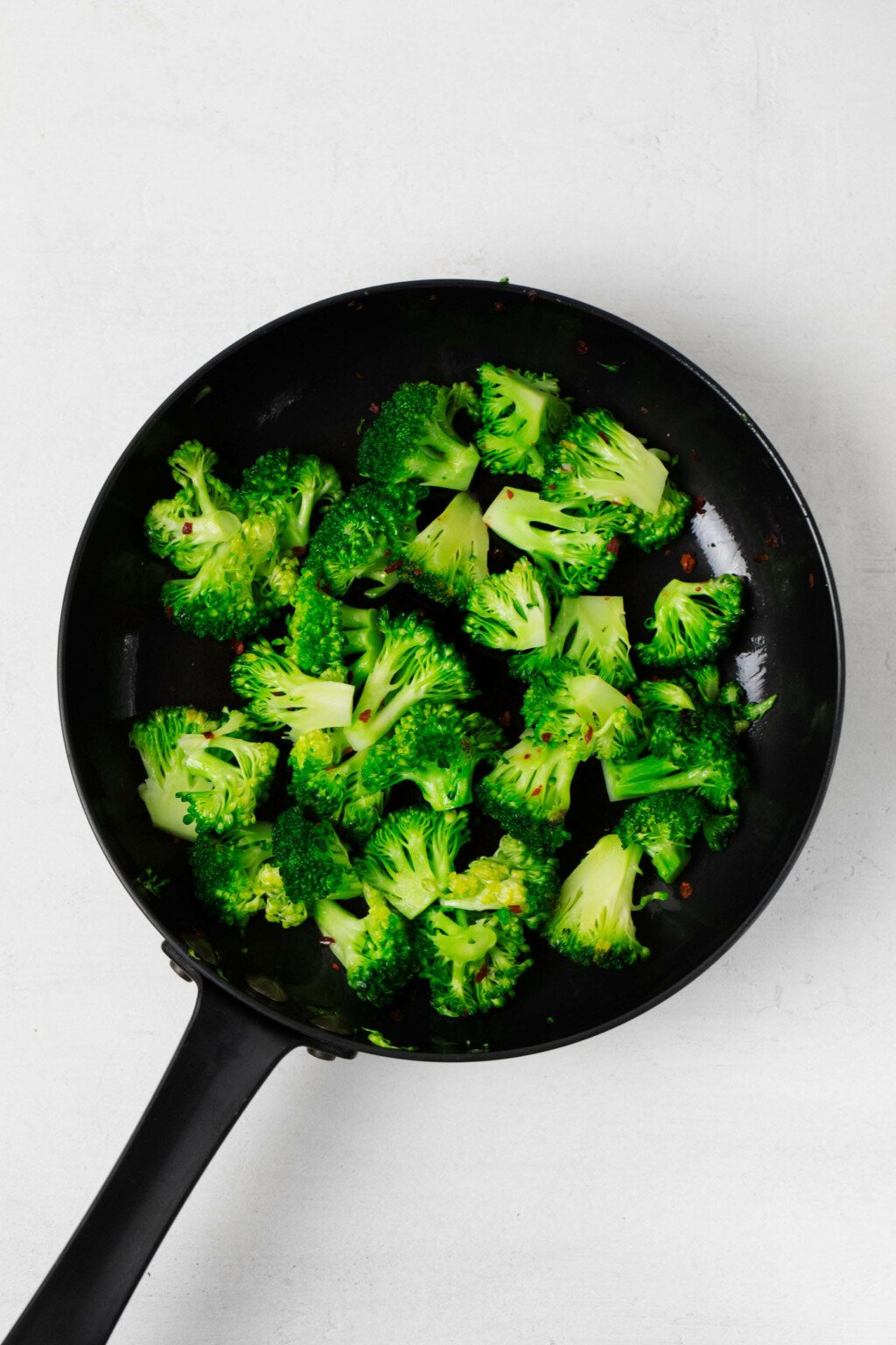 Cooking broccoli florets in a cast iron skillet.