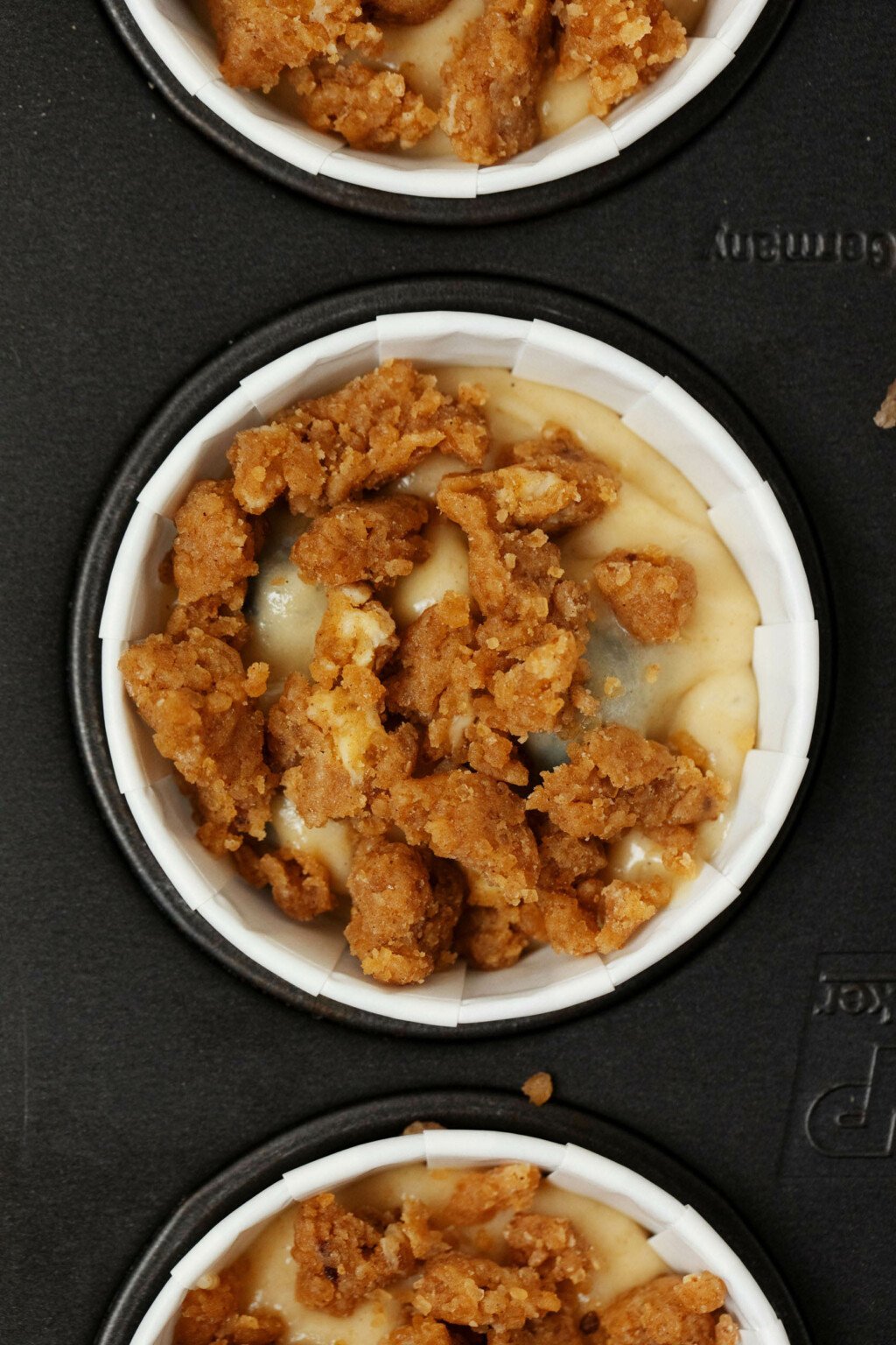 An image of the top of a muffin that has been piled with crumb topping.