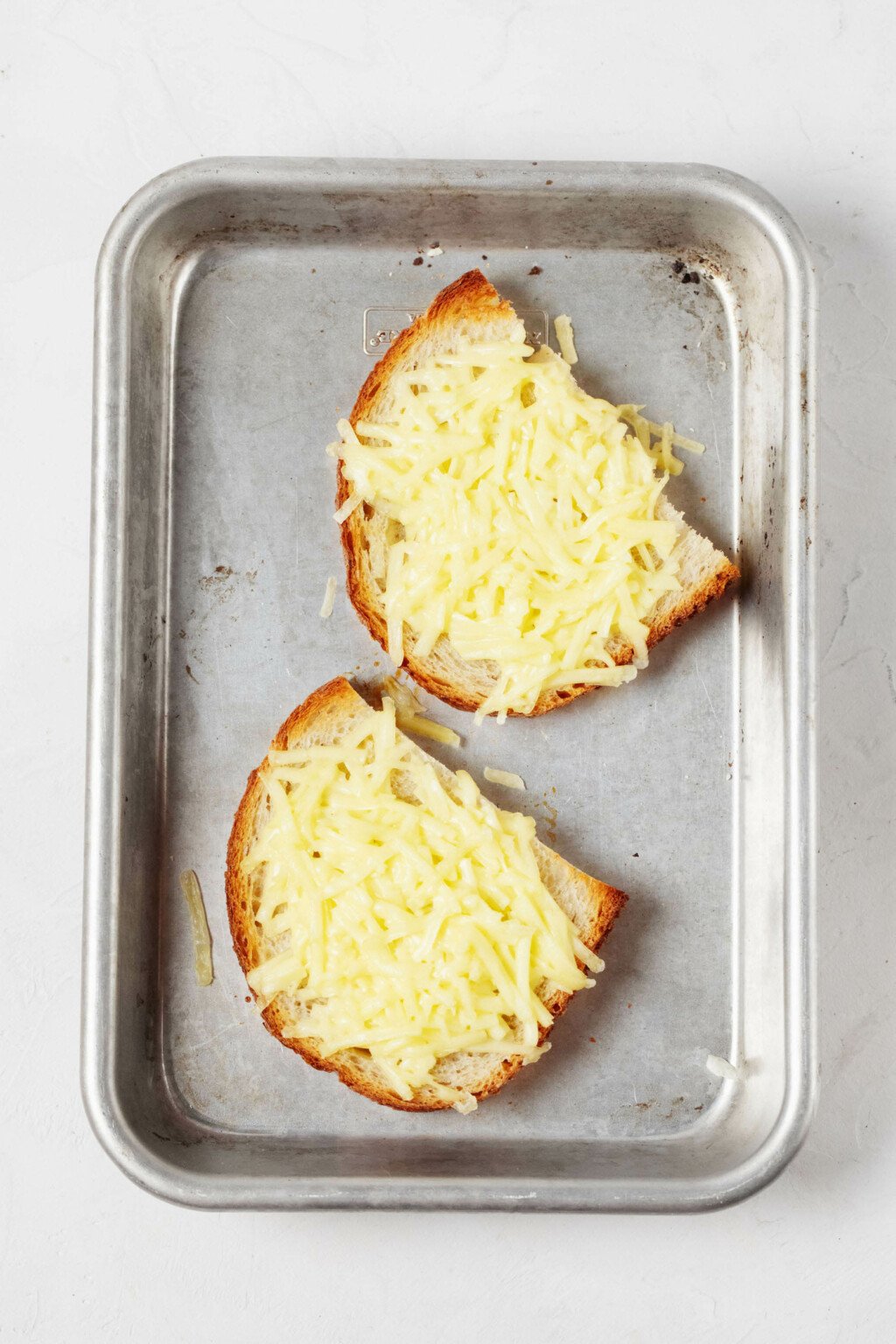 An overhead image of toasted bread with melted, plant-based "cheese" on top.
