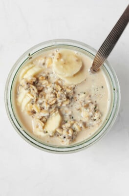 An overhead image of the mouth of a jar, which has been filled with plant-based overnight oats.