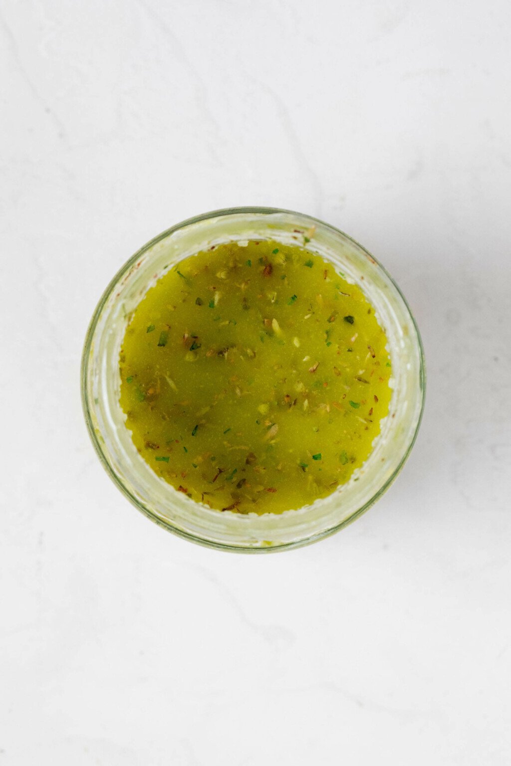 An overhead image of a small bowl of vegan Italian dressing.