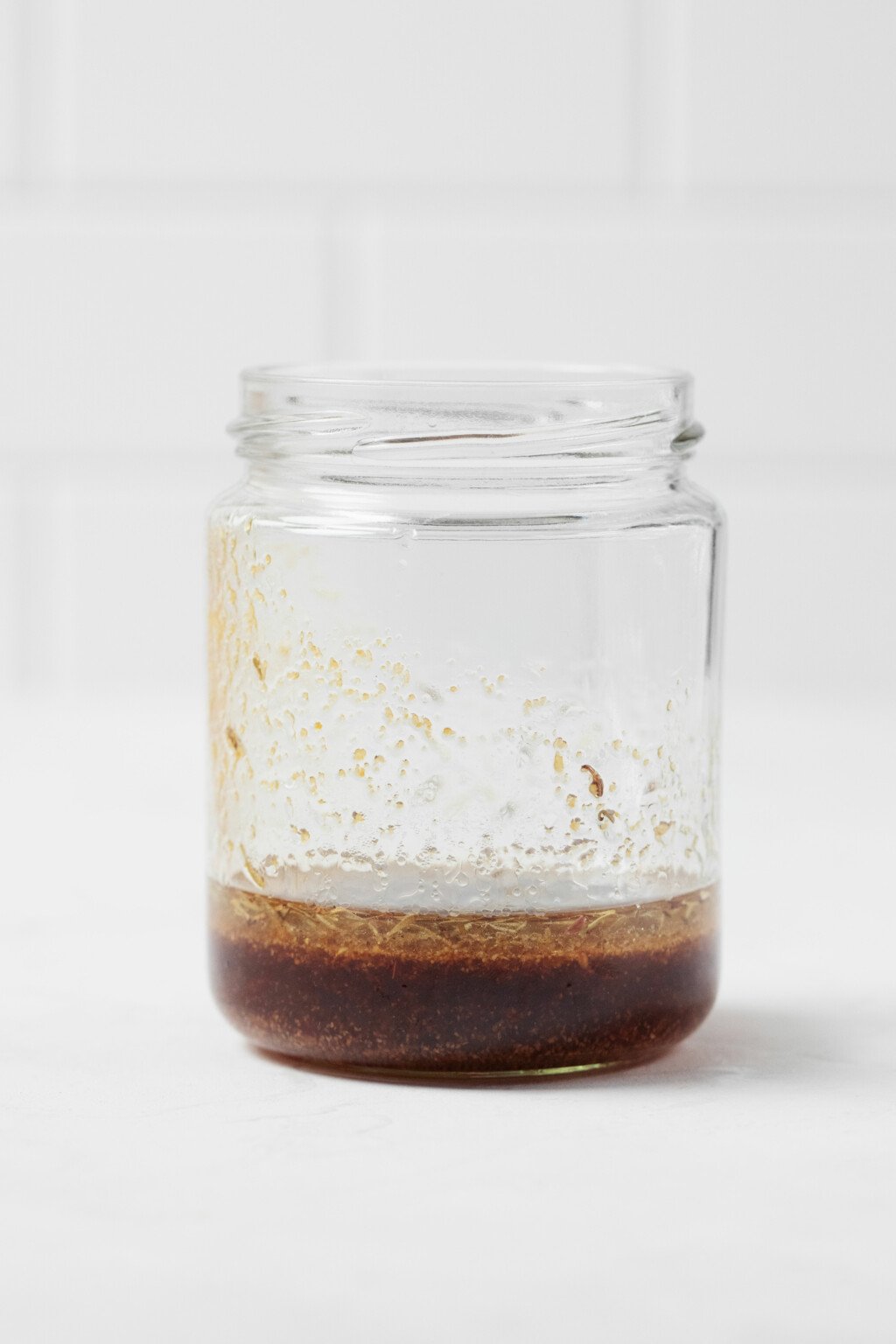 An image of a clear, glass jar, which is filled with a brown-colored marinade.