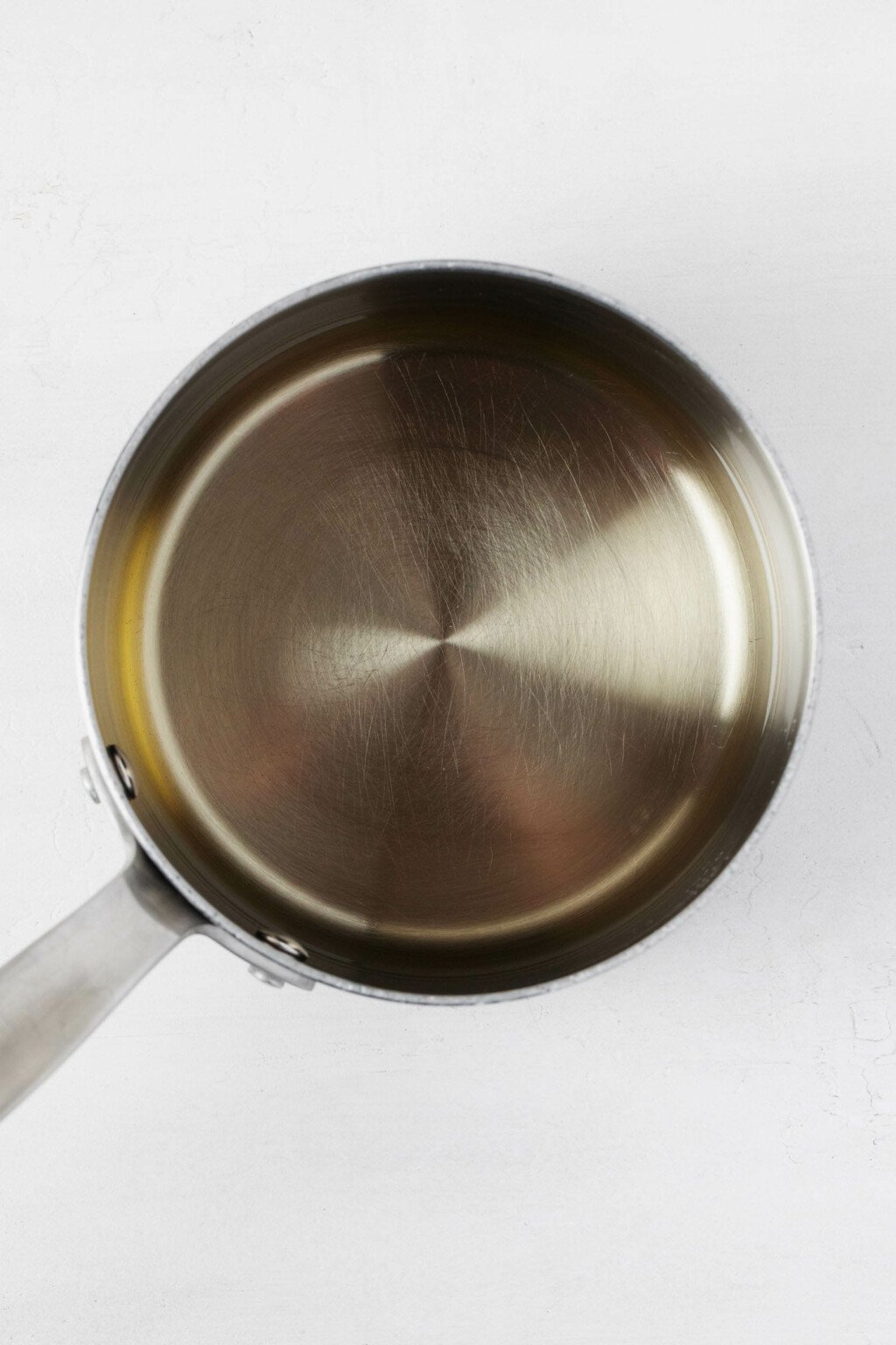 An overhead image of a small, metal saucepan filled with pickling liquid.