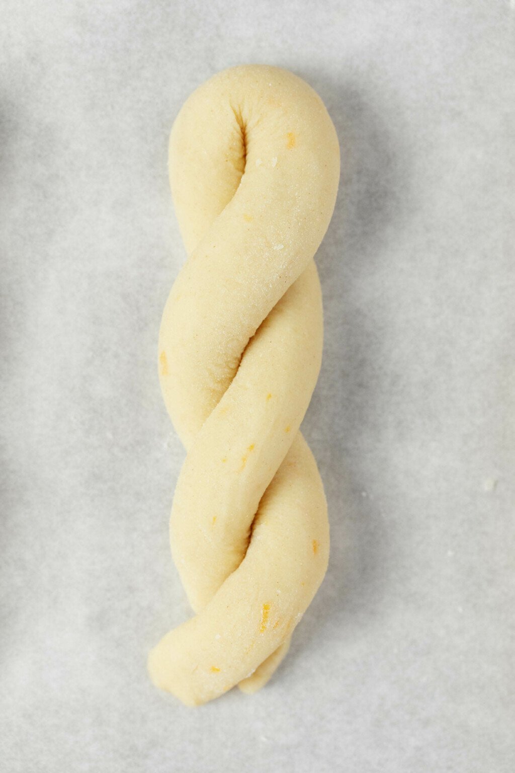 An overhead image of a twisted rope of cookie dough on a baking sheet.