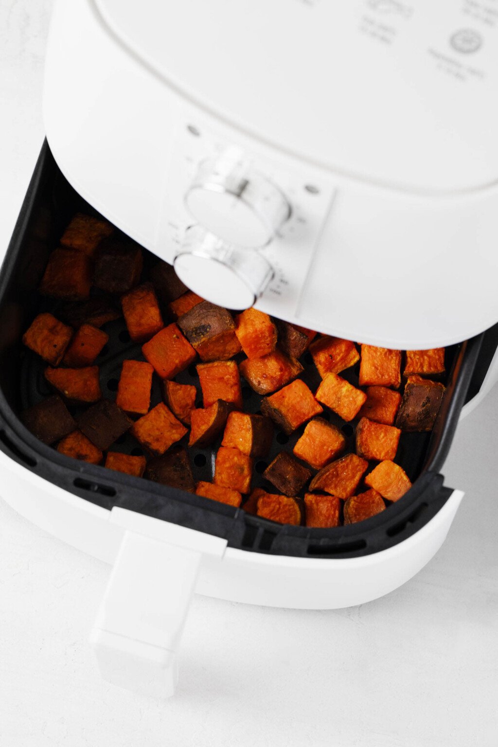 A tabletop appliance is used to cook cube vegetables.